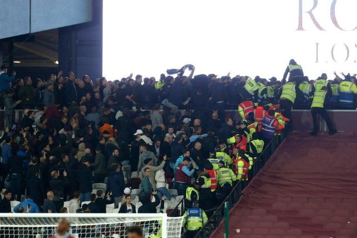 Police and stewards try to separate supporters of West Ham United and Chelsea as they confront each other during the English Football League Cup fourth round match on October 26, 2016
