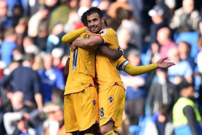 Crystal Palace's Luka Milivojevic (R) and Wilfried Zaha embrace on the pitch at the final whistle of their match against Chelsea at Stamford Bridge in London on April 1, 2017