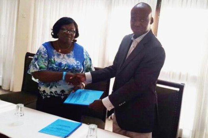 Dr H.N. Akubuiro, (left) the Vice-President of the council of the Chartered Institute of Loans and Risk Management, Nigeria, presenting the memorandum of understanding to Mr Adam Sulley, the President of the Institute of Loans and Risk Management, Ghan...