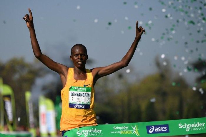 Kenya's Paul Lonyangata raises the arms as he crosses the finish line to win the 41st Paris Marathon in Paris on April 9, 2017