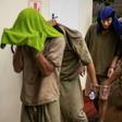 Chinese nationals cover their faces from cameras with towels as they leave the courtroom on January 3, 2019, at the Victoria Falls magistrate court where they faced charges of breaching Zimbabwe's wildlife laws for possessing rhino horn pieces