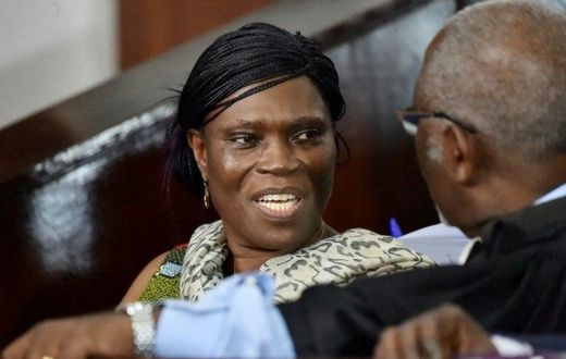 Former Ivorian first lady Simone Gbagbo (L) talks to her lawyer at the Abidjan's courthouse on October 10, 2016 before the re-opening of her trial, during which she was prevented from leaving the courtroom by military police November 29, 2016