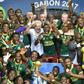 Cameroon team players and coach Hugo Broos (C) celebrate with the winner's trophy after beating Egypt 2-1 to win the 2017 Africa Cup of Nations final football match on February 5, 2017