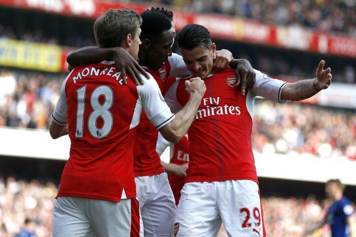 Arsenal players celebrate after scoring the opening goal of the English Premier League football match against Manchester United in London on May 7, 2017