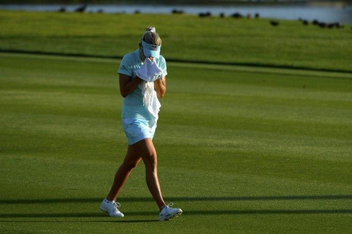Lexi Thompson cries in a towel as she walks to the 18th green after her second shot during the final round of the ANA Inspiration on the Dinah Shore Tournament Course on April 2, 2017 in California
