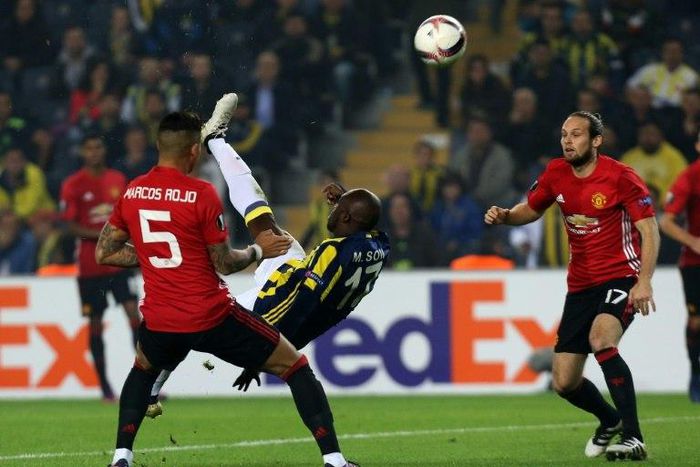 Fenerbahce's Moussa Sow bicycle-kicks the ball next to Manchester United's Marcos Rojo (L) and Daley Blind, in Istanbul, on November 3, 2016