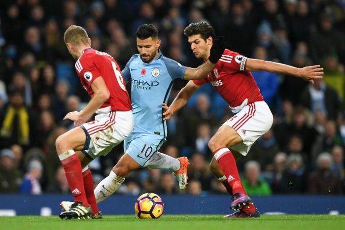 Manchester City's Sergio Aguero (C) tries to find a gap between Middlesbrough's Ben Gibson (L) and George Friend