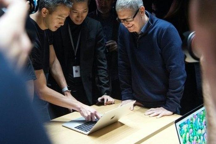 Apple plans to borrow for its new "advanced manufacturing" fund despite having money overseas, because of the tax it would pay if it brought profit home, said CEO Tim Cook (R)