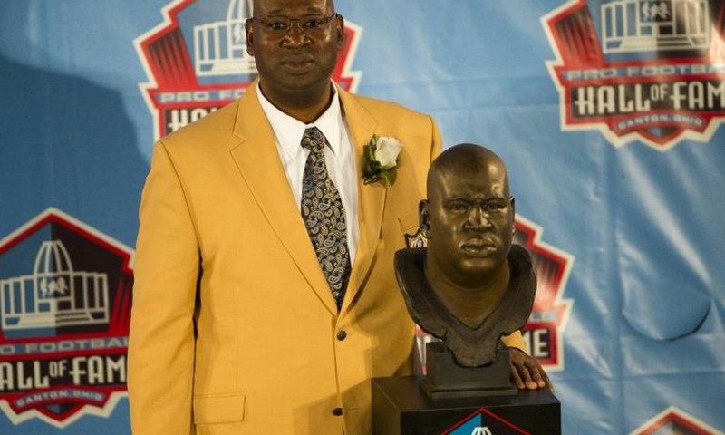 Former Seattle Seahawks defensive tackle Cortez Kennedy poses with his bust during the Class of 2012 Pro Football Hall of Fame enshrinement ceremony
