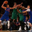 Joakim Noah and Kristaps Porzingis of the New York Knicks pursue the loose ball against Marcus Smart and Amir Johnson of the Boston Celtics at Madison Square Garden on December 25, 2016