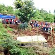 People look at the wreckage of a bus that plunged into a gorge while transporting children from Arusha to Karatu, on May 6, 2017