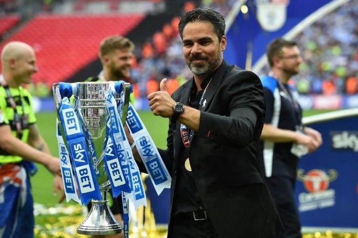 Huddersfield Town's head coach David Wagner gestures as he holds the Championship Playoff trophy on the pitch after winning the penalty shoot-out in the English Championship play-off final football match against and Reading