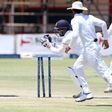 Zimbabwe's batsman Hamilton Masakadza (left) survives a run out attempt by wicketkeeper Kusal Janith Perera during a Test match in Harare, on November 2, 2016
