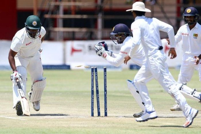 Zimbabwe's batsman Hamilton Masakadza (left) survives a run out attempt by wicketkeeper Kusal Janith Perera during a Test match in Harare, on November 2, 2016