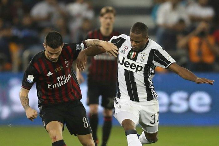 Juventus' Patrice Evra (R) vies for the ball with AC Milan's Fernandez Suso during the Italian Super Cup final match between AC Milan and Juventus in Doha on December 23, 2016