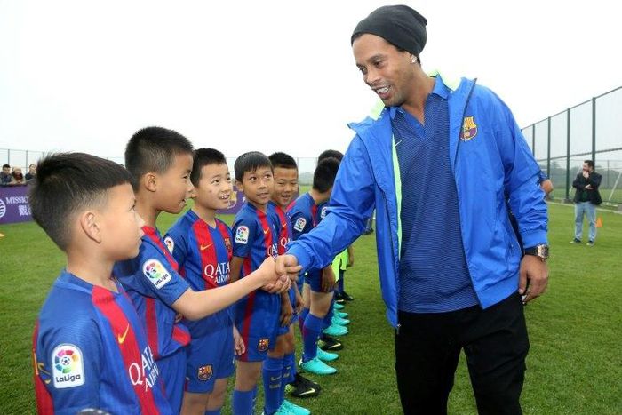 Brazilian player Ronaldinho meets children at the launch of a Barcelona football academy on the southern Chinese island of Hainan, on February 24, 2017