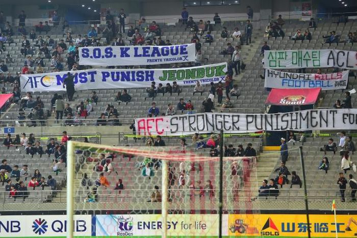 South Korean football fans display banners protesting against Jeonbuk Hyundai Motors' bribing of referees before a match in Seoul in October 2016