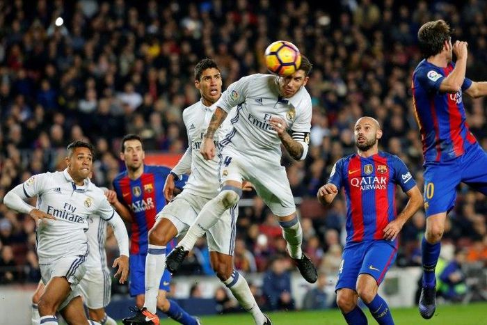 Real Madrid's defender Sergio Ramos (C) heads a ball to score the equalizer past Real Madrid's Raphael Varane (3rdL) and Barcelona's defender Javier Mascherano (R) during the Spanish league football match on December 3, 2016
