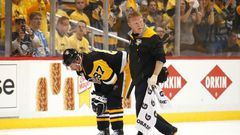 Sidney Crosby of the Pittsburgh Penguins leaves the ice with trainer Chris Stewart after taking a hit while playing the Washington Capitals on May 1, 2017