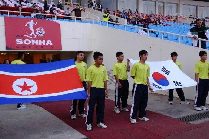 Flags of North Korea (L) and South Korea are carried prior to a football match between the two countries' U-23 teams during the Vietnam Football (VFF) Federation Son Ha Cup tournament on November 4, 2010