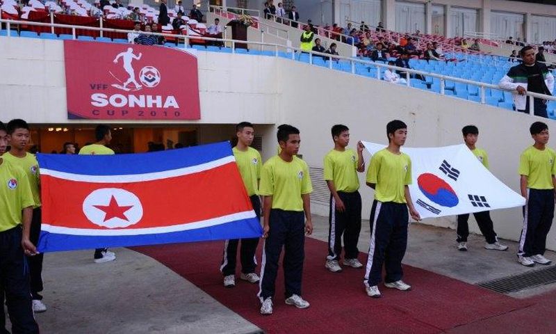 Flags of North Korea (L) and South Korea are carried prior to a football match between the two countries' U-23 teams during the Vietnam Football (VFF) Federation Son Ha Cup tournament on November 4, 2010