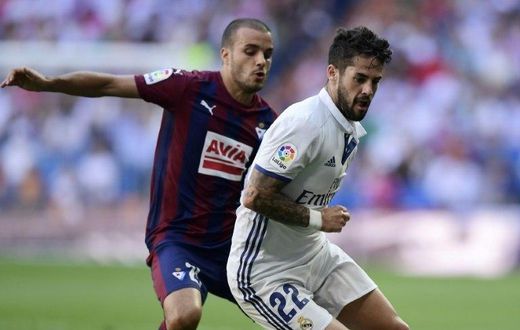 Real Madrid's Isco (R) fights for the ball with Eibar's midfielder Pedro Leon during their Spanish La Liga match in Madrid, in October 2016