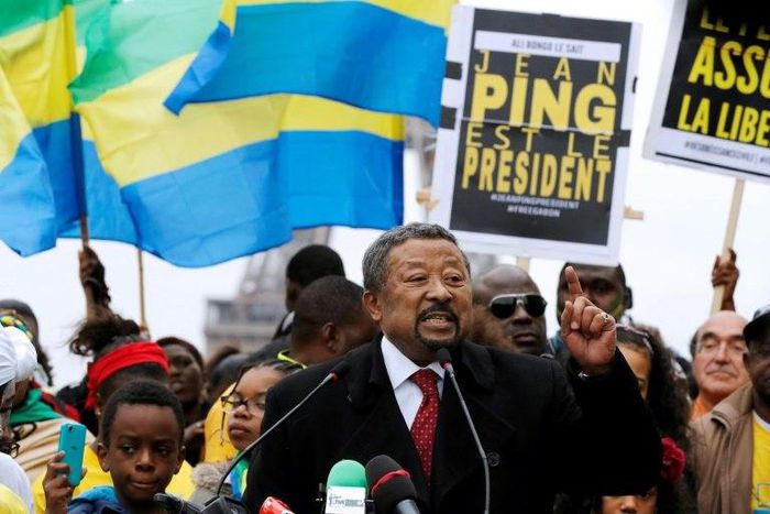 Gabonese opposition leader Jean Ping (C), surrounded by supporters waving Gabonese flags, gestures as he speaks on the Human Rights Esplanade