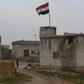 A Syrian national flag flies as regime forces gather in the countryside south of the northern Kurdish-controlled city of Manbij on December 30, 2018
