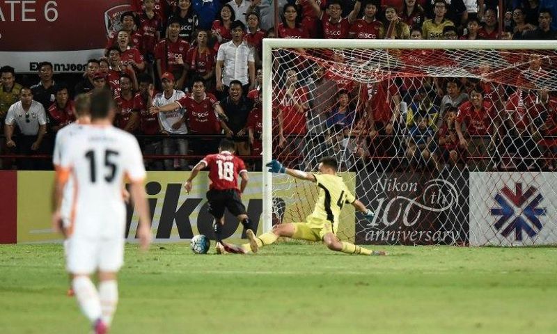 Muangthong United supporters watch intently as Chanathip Songkrasin of Muangthong United (C) rounds Brisbane Roar's goalkeeper Jamie Young to score a goal during their AFC Asian Champions League match, at the SCG Stadium in Bangkok, on April 26, 2017