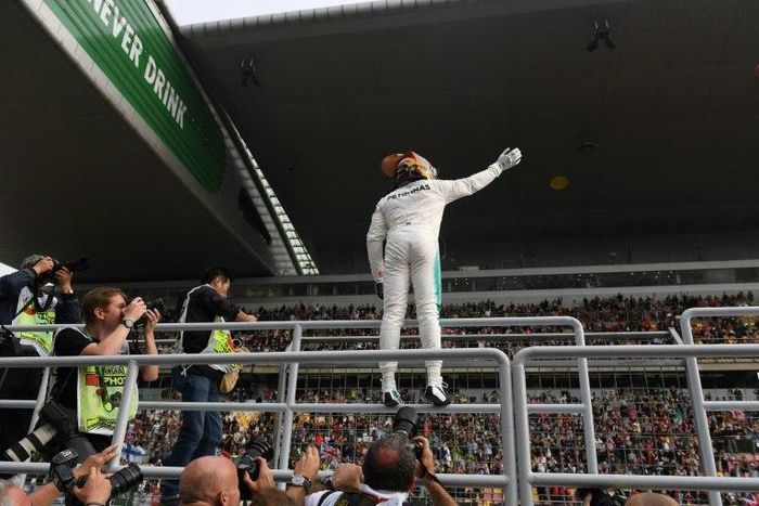 Mercedes' British driver Lewis Hamilton waves to fans after taking pole position in qualifying for the Formula One Chinese Grand Prix in Shanghai