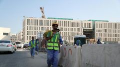 Migrant workers are seen walking next to a construction site in the Qatari capital Doha on December 6, 2016