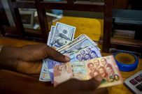 A man trades U.S. dollars for Ghanaian cedis at a currency exchange office in Accra, Ghana, June 15, 2015. Picture taken June 15. REUTERS/Francis Kokoroko