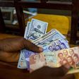 A man trades U.S. dollars for Ghanaian cedis at a currency exchange office in Accra, Ghana, June 15, 2015. Picture taken June 15. REUTERS/Francis Kokoroko
