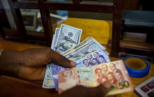 A man trades U.S. dollars for Ghanaian cedis at a currency exchange office in Accra, Ghana, June 15, 2015. Picture taken June 15. REUTERS/Francis Kokoroko