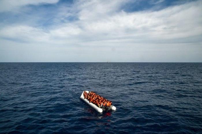 Migrants and refugees on a rubber boat wait to be evacuated on November 5, 2016 off the coast of Libya