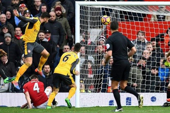 Arsenal's French striker Olivier Giroud (left) scores his team's first goal during the English Premier League match against Manchester United at Old Trafford in Manchester on November 19, 2016
