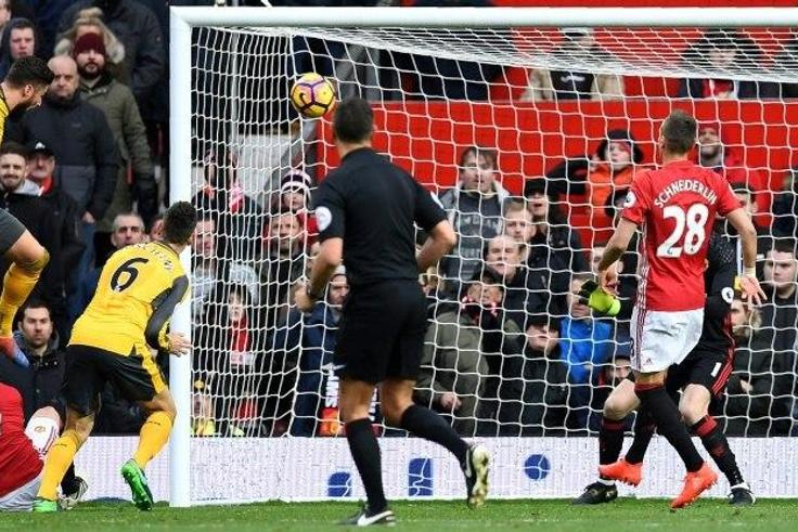 Arsenal's French striker Olivier Giroud (left) scores his team's first goal during the English Premier League match against Manchester United at Old Trafford in Manchester on November 19, 2016