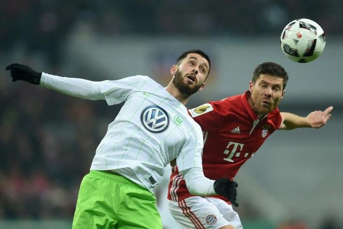 Bayern Munich's midfielder Xabi Alonso (R) and Wolfsburg's midfielder Yunus Malli vie for the ball during the German Cup DFB Pokal Round of 16 football match FC Bayern Munich v VFL Wolfburg in Munich, southern Germany on February 7, 2017