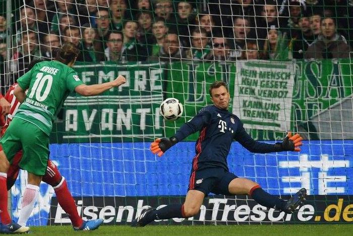 Bremen's midfielder Max Kruse (2L) scores against Bayern Munich's goalkeeper Manuel Neuer during the German first division Bundesliga football match of Werder Bremen vs FC Bayern Munich in Bremen , nothern Germany, on January 28, 2017
