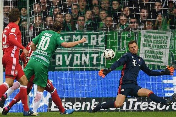 Bremen's midfielder Max Kruse (2L) scores against Bayern Munich's goalkeeper Manuel Neuer during the German first division Bundesliga football match of Werder Bremen vs FC Bayern Munich in Bremen , nothern Germany, on January 28, 2017