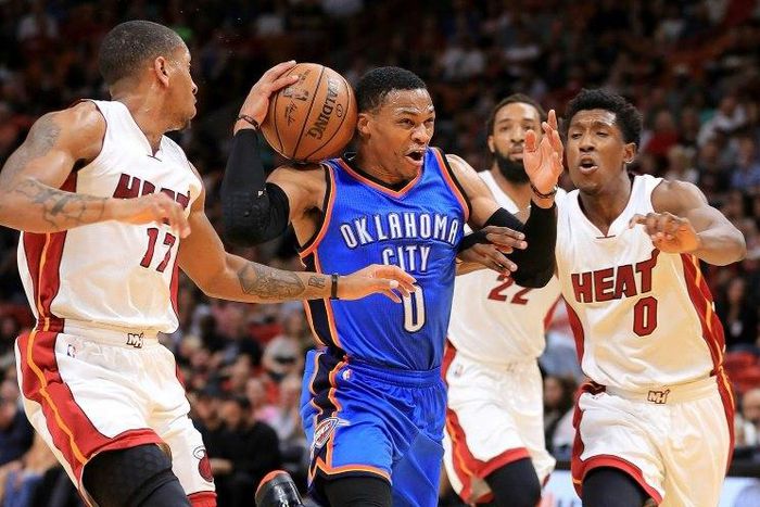 Russell Westbrook of the Oklahoma City Thunder drives on Josh Richardson (R) and Rodney McGruder of the Miami Heat during their NBA game at American Airlines Arena in Miami, Florida, on December 27, 2016