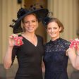 Former Great Britain hockey captain Kate Richardson-Walsh (L) and her wife Helen pose at Buckingham Palace in London after the investiture ceremony where they received an OBE and MBE respectively on February 17, 2017
