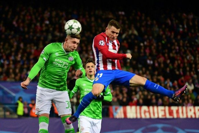 Atletico Madrid's forward Kevin Gameiro (R) jumps for the ball against PSV Eindhoven's defender Jordy De Wijs on November 23, 2016