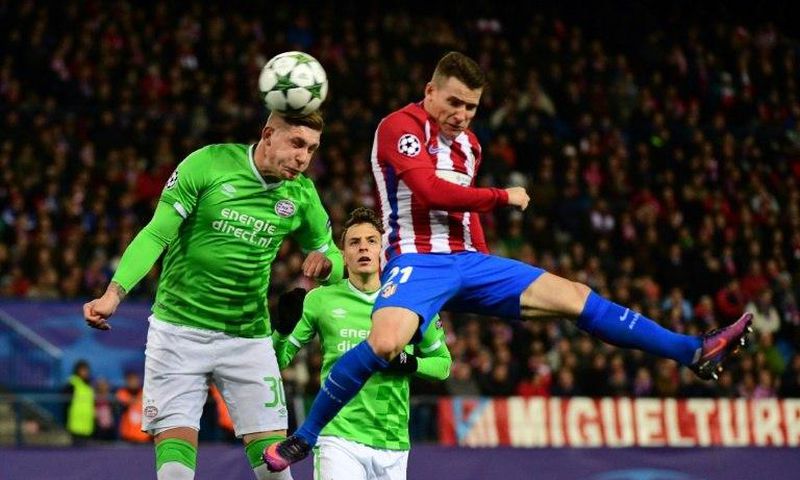 Atletico Madrid's forward Kevin Gameiro (R) jumps for the ball against PSV Eindhoven's defender Jordy De Wijs on November 23, 2016