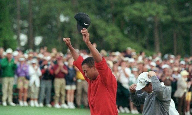Tiger Woods raises his arms in victory after winning the 1997 Masters tournament, a turning point for the sport, the man and even the course