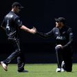 Martin Guptill is helped by teammate Neil Broom of New Zealand after fielding a ball during a match between New Zealand and Australia in Auckland on January 30, 2017