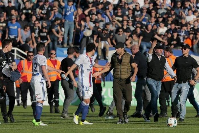 A Bastia's official (C-R) argues with Lyon's Brazilian defender Rafael da Silva (C-L) during scuffles at half-time between some of Lyon's players and Bastia's officials, during the French L1 football match Bastia vs Lyon on April 16, 2017