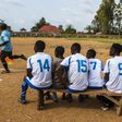 Local football players follow a match from the bench in Beni, DR Congo