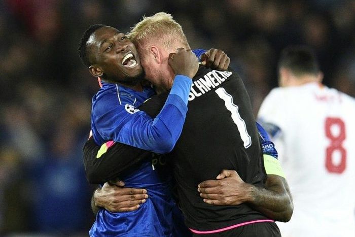 Leicester City's Wilfred Ndidi (L) and goalkeeper Kasper Schmeichel celebrate victory at the end of their UEFA Champions League round of 16 2nd leg match against Sevilla, at the King Power Stadium in Leicester, on March 14, 2017