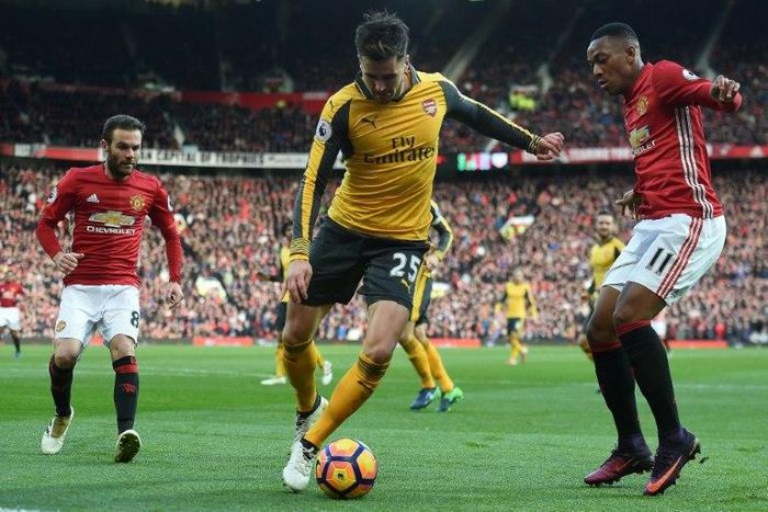 Arsenal's defender Carl Jenkinson (C) vies with Manchester United's striker Anthony Martial (R) and midfielder Juan Mata during the English Premier League football match November 19, 2016